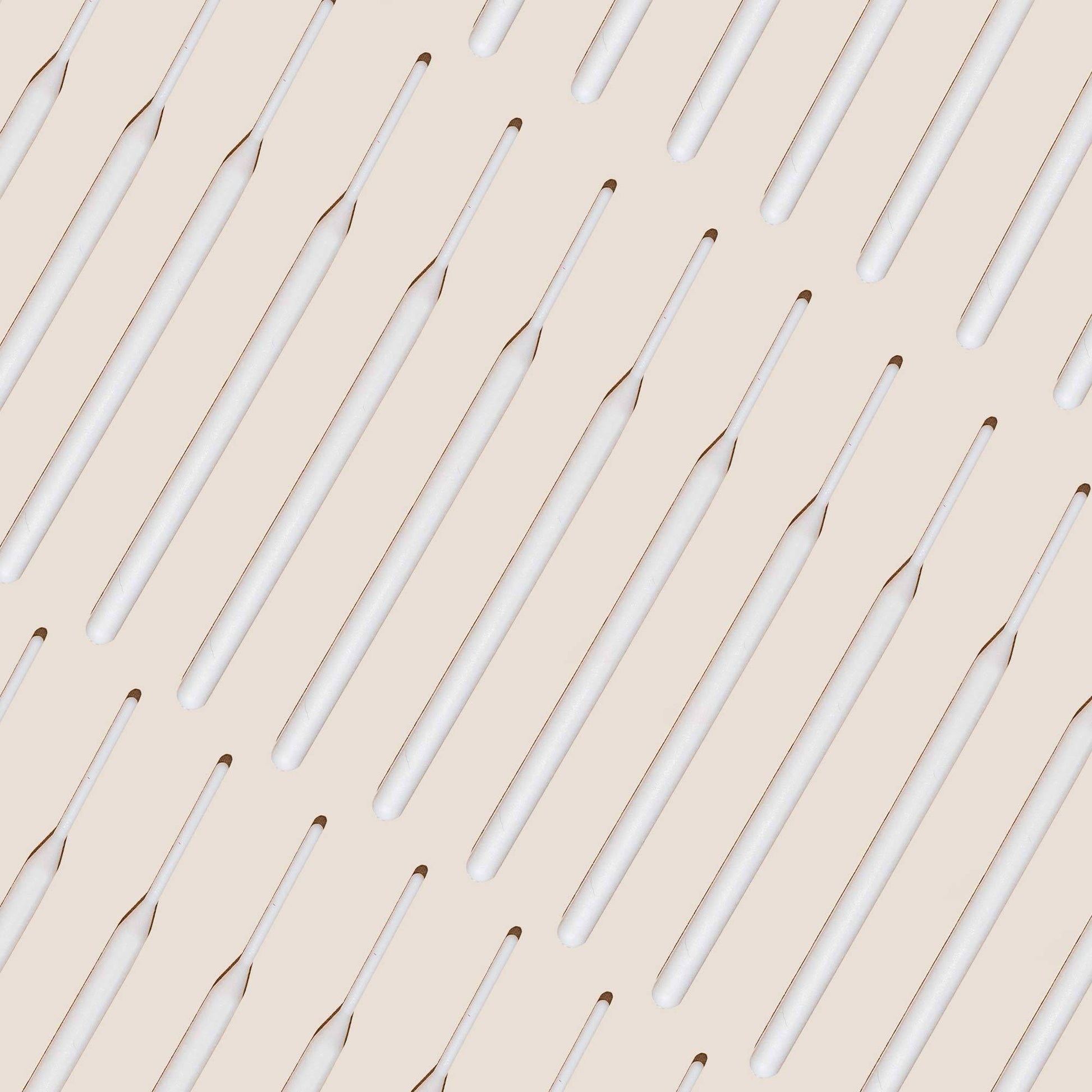 Numerous tinting sticks laid out against an off white background