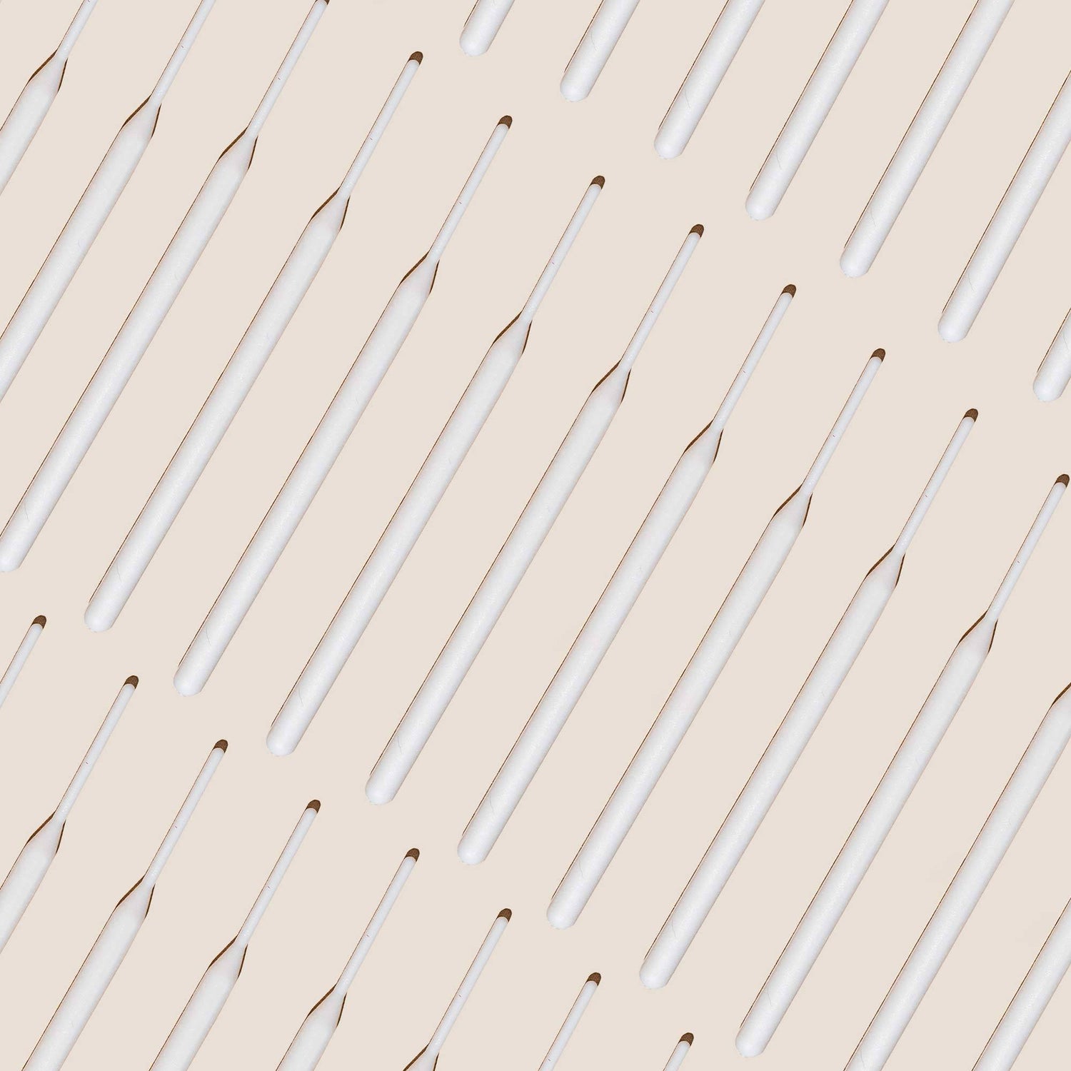 Numerous tinting sticks laid out against an off white background